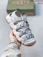 Angled side view of the white and gray KEEN sandal with tan outsole sections.