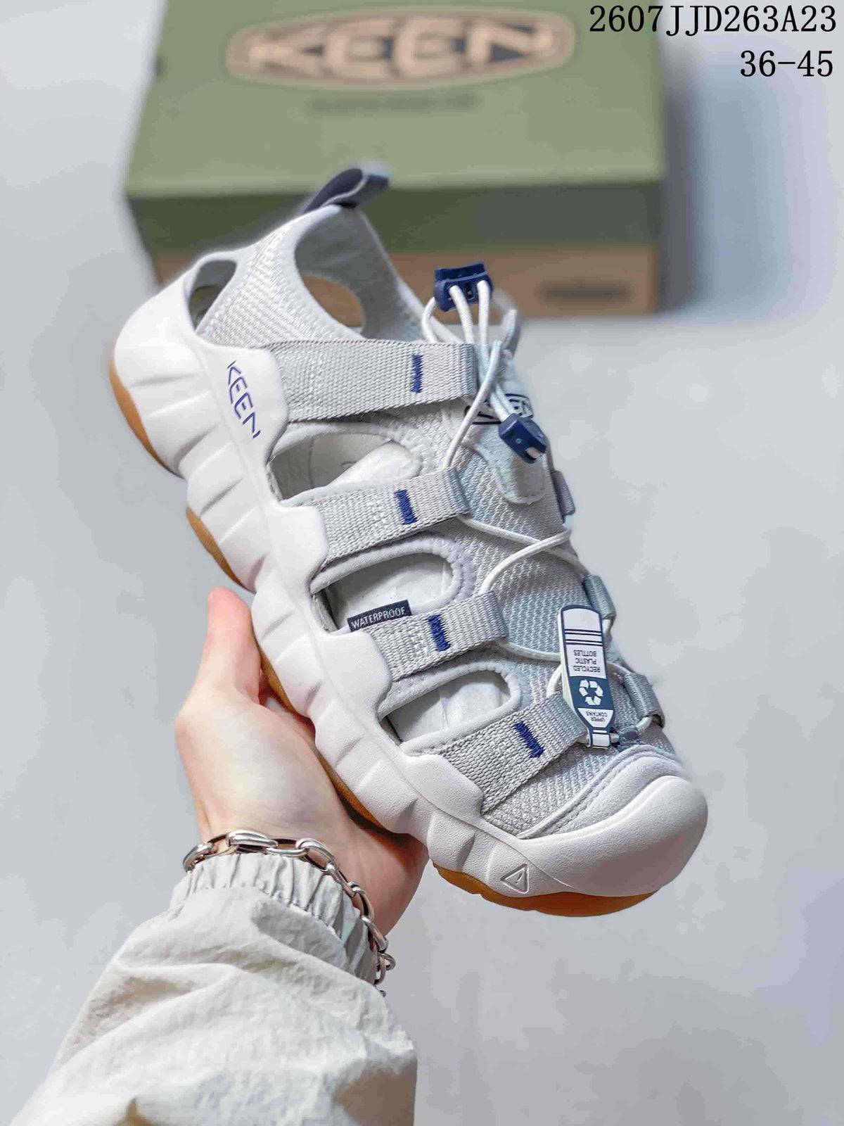 Angled side view of the white and gray KEEN sandal with tan outsole sections.