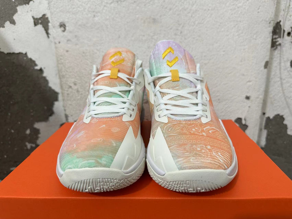 Front view of pastel-patterned Nike basketball shoes with white laces and yellow tongue details.