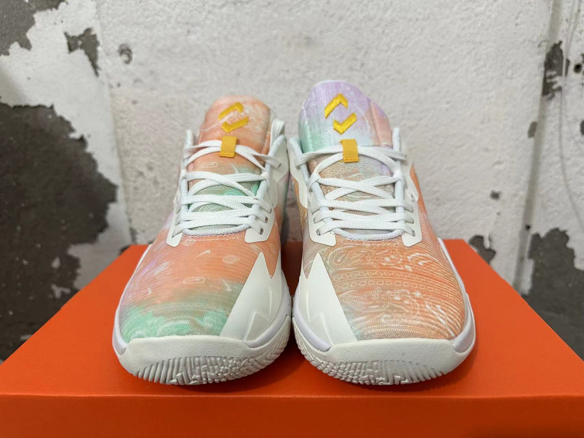 Front view of pastel-patterned Nike basketball shoes with white laces and yellow tongue details.