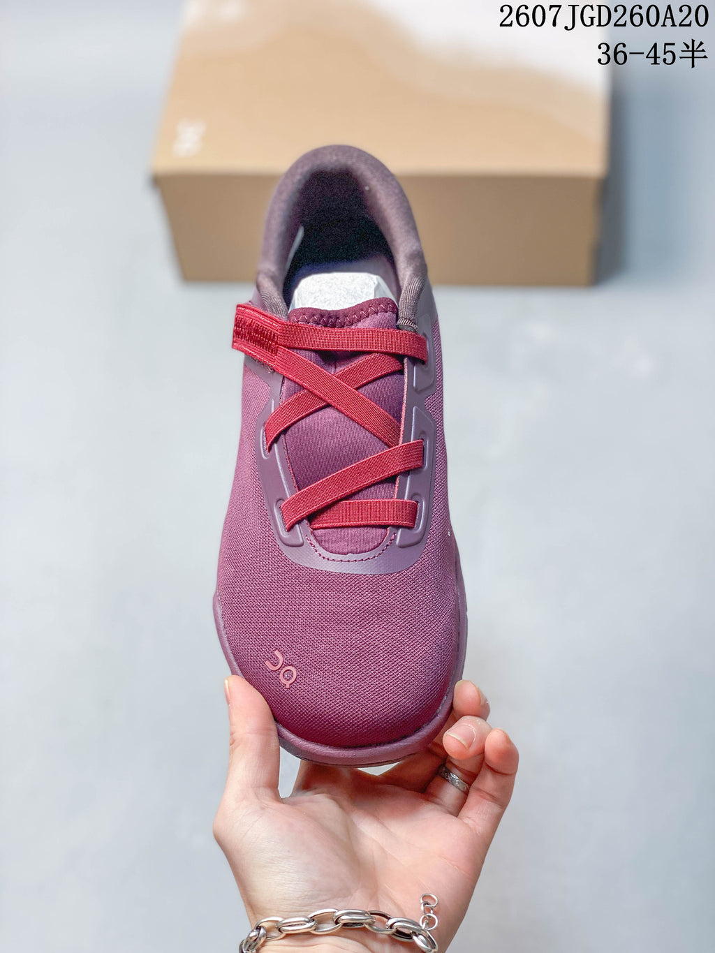 Top view of one plum-purple sneaker showing the red-pink webbing, adjustable strap, padded collar, and tongue.