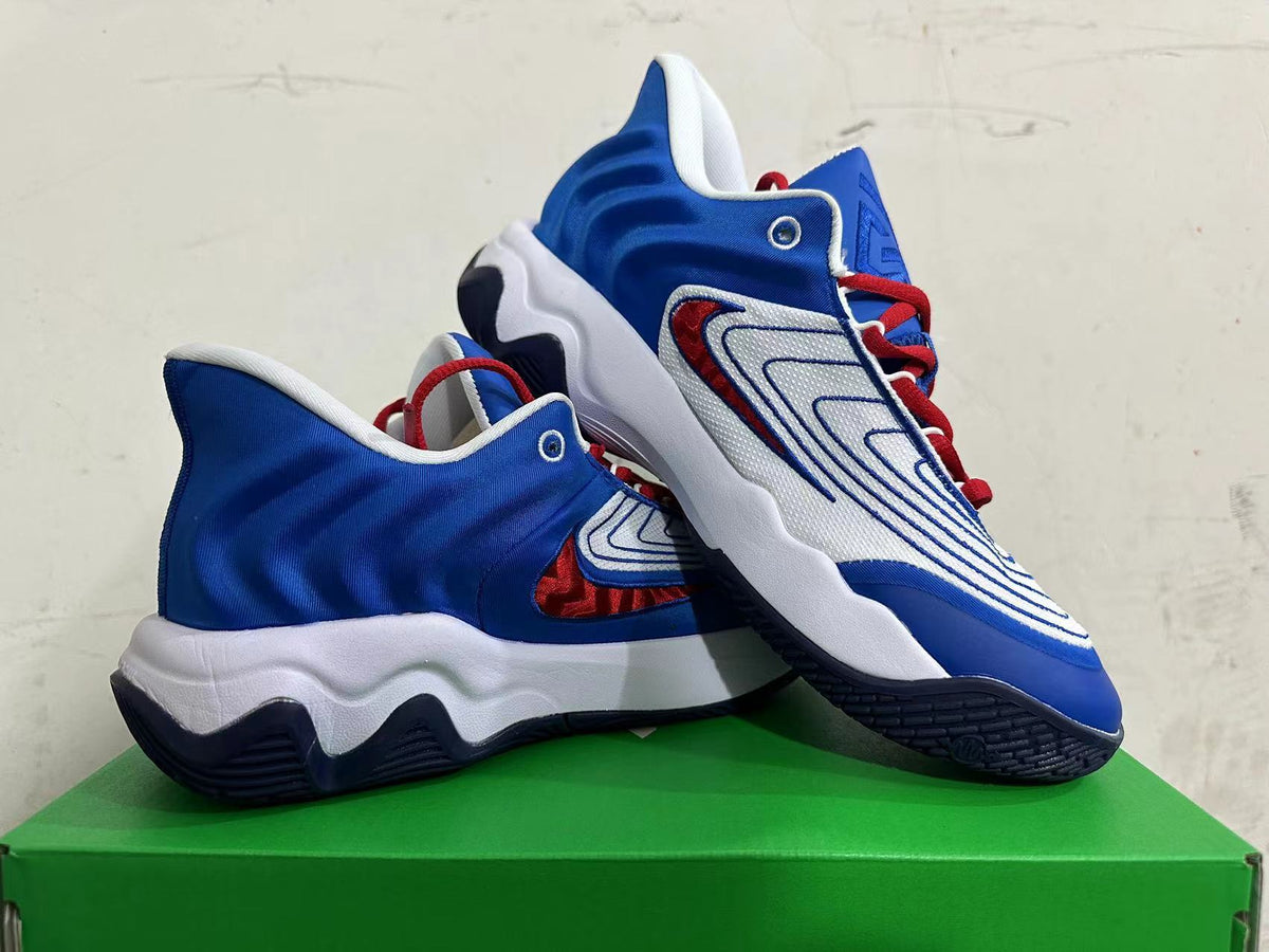 Pair of white, blue, and red Nike basketball shoes shown from the side.