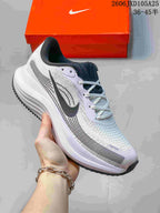 Side view of a white Nike Air Zoom Pegasus running shoe with dark detailing.