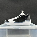 Side view of a black-and-white Jordan 39 low-top basketball shoe with white laces and a sculpted light-colored sole.