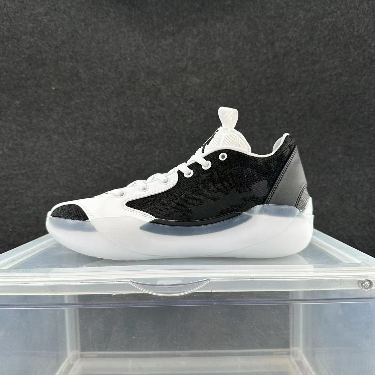 Side view of a black-and-white Jordan 39 low-top basketball shoe with white laces and a sculpted light-colored sole.