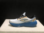 Side profile of one Brooks Glycerin 21 sneaker showing the white upper, blue heel and midsole, and layered side logo detail.