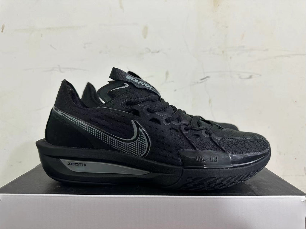 Side view of an all-black Nike sneaker with dotted Swoosh and ZoomX midsole marking
