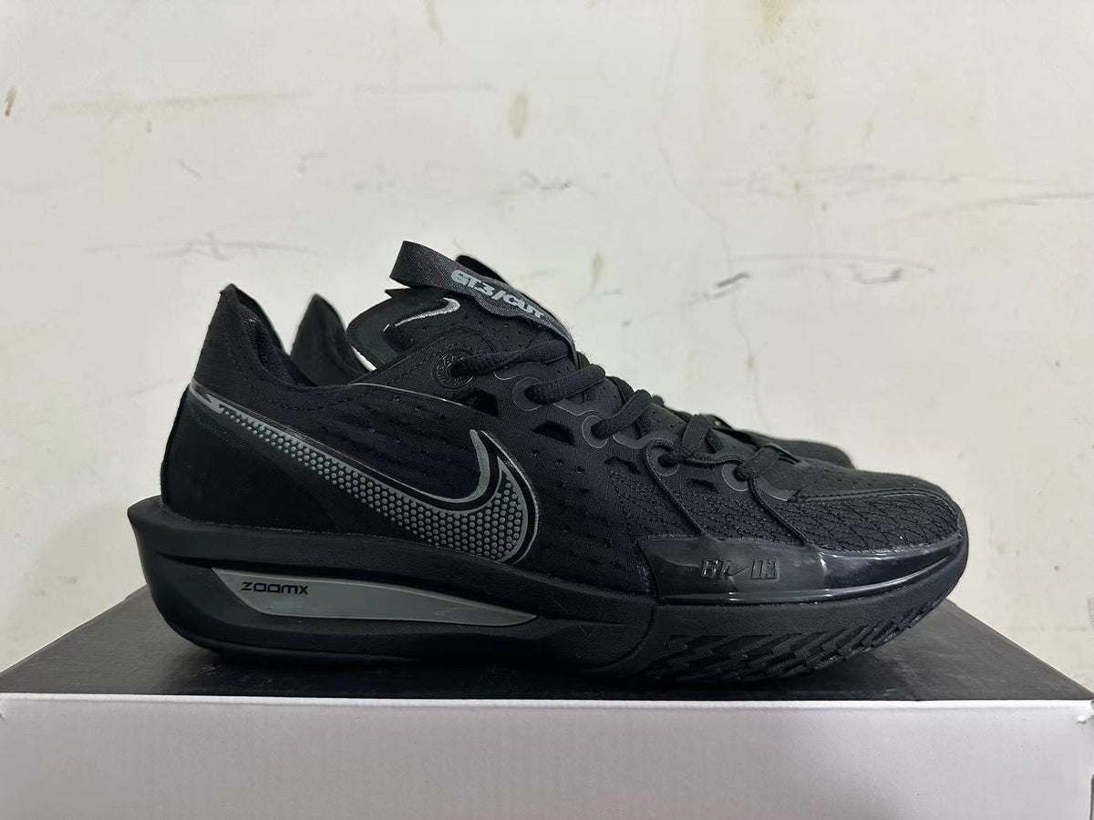 Side view of an all-black Nike sneaker with dotted Swoosh and ZoomX midsole marking