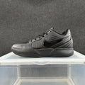 Side view of an all-black Nike low-top sneaker with a lace-up closure, side Swoosh, and Air Zoom midsole branding.