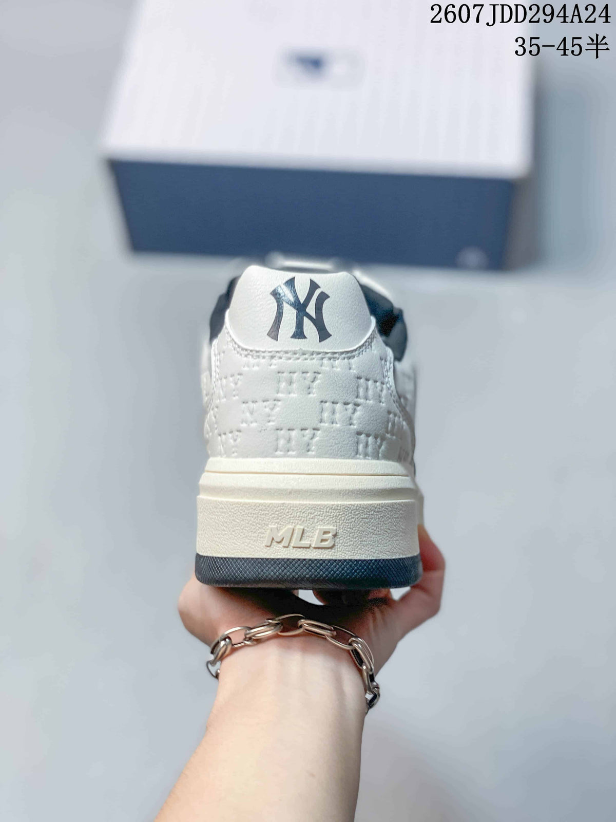 Rear view of the white sneaker showing the navy-accented heel, raised sole, and MLB branding.