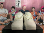 Front view of beige lace-up sneakers with rounded toe panels