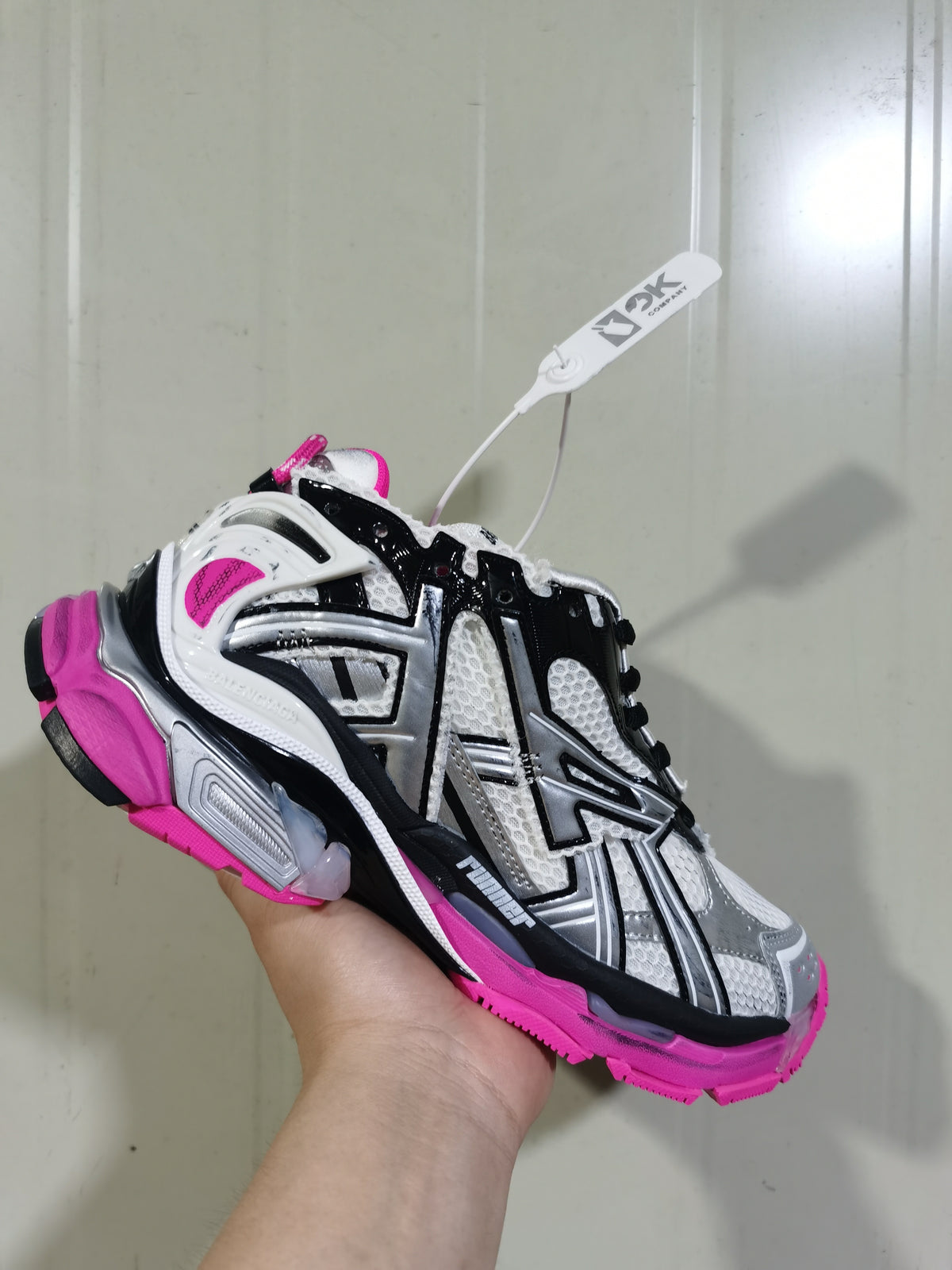 Three-quarter view of silver, black and fluorescent pink 9155 runner sneakers with layered panels and mesh sections.