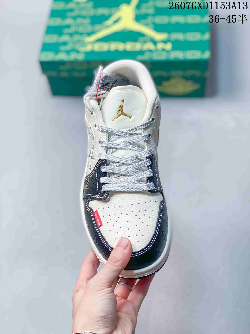 Top view showing the perforated white toe box, woven laces, navy overlays, and gold tongue emblem.
