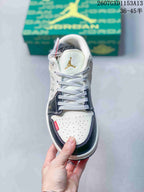 Top view showing the perforated white toe box, woven laces, navy overlays, and gold tongue emblem.
