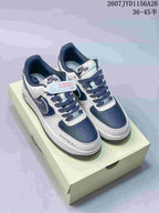 Pair of white and navy Nike Air Force 1 low-top sneakers displayed on a shoebox, with dark laces and visible side graphics.