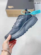 Side profile of the dark gray low-top sneaker showing the lace area, layered upper, and textured sole.