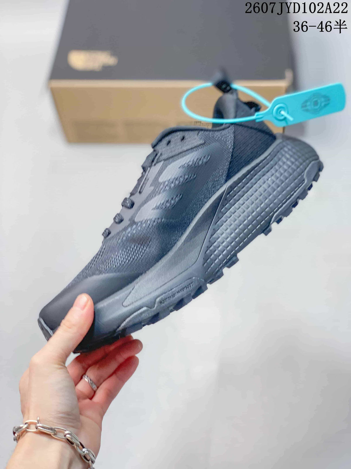 Side profile of the dark gray low-top sneaker showing the lace area, layered upper, and textured sole.