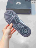 Close view of the black rubber outsole with concentric circular tread and Air branding; a Nike Air Force 1 shoebox is in the background.