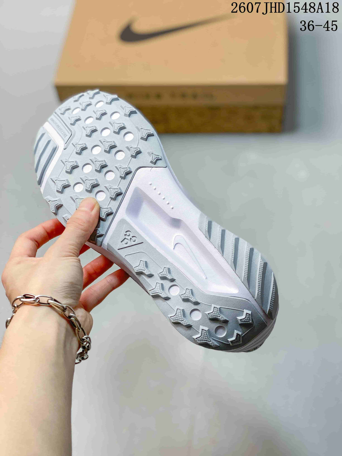 Close view of the sneaker outsole showing a white lugged tread pattern with circular openings.