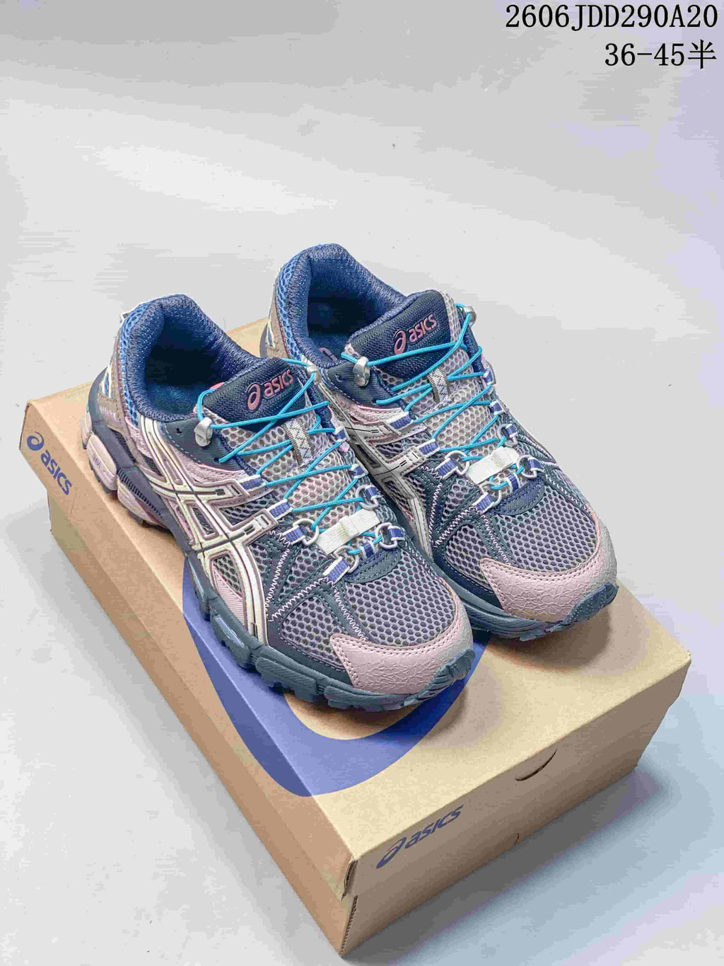 Pair of ASICS Tiger Gel-Kahana 8 sneakers in gray, navy, pink and bright blue, displayed on an ASICS shoe box.