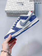 Side profile showing blue and white panels, gray swoosh-style overlay, white midsole, and blue outsole.