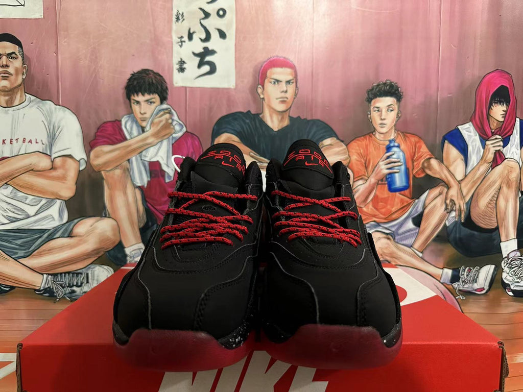 Front view of black Nike basketball sneakers with red laces and red tongue details.