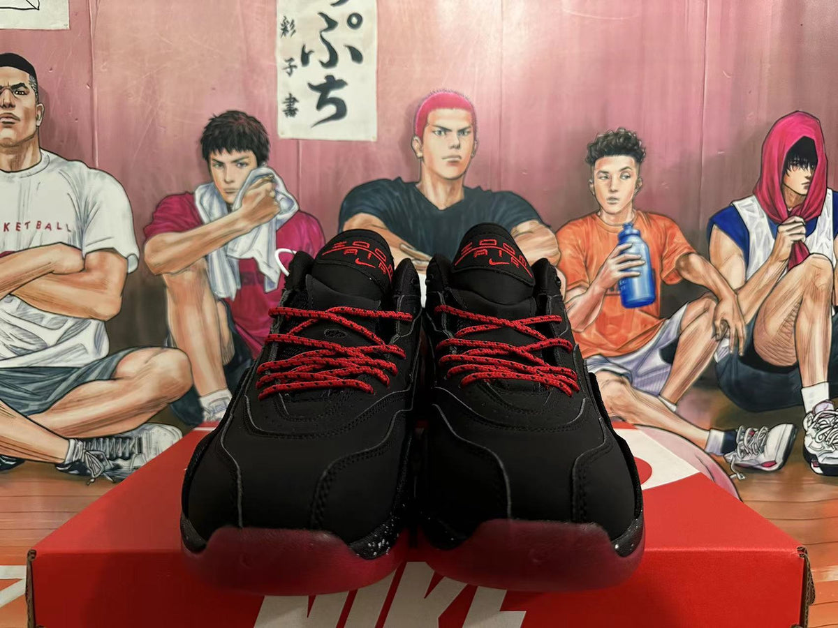Front view of black Nike basketball sneakers with red laces and red tongue details.