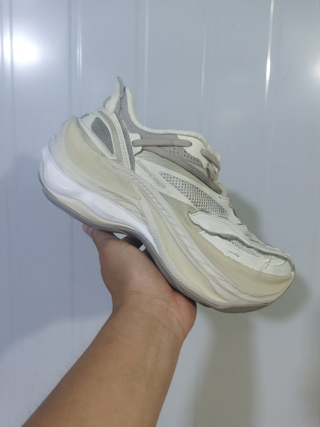 Angled view of the Balenciaga sneakers highlighting the branded side panel, mesh upper, layered construction, and thick sole.
