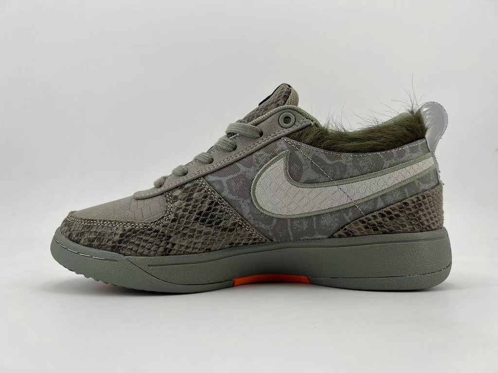 Side profile of the gray patterned sneakers with a light Swoosh and orange outsole accent