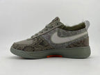 Side profile of the gray patterned sneakers with a light Swoosh and orange outsole accent