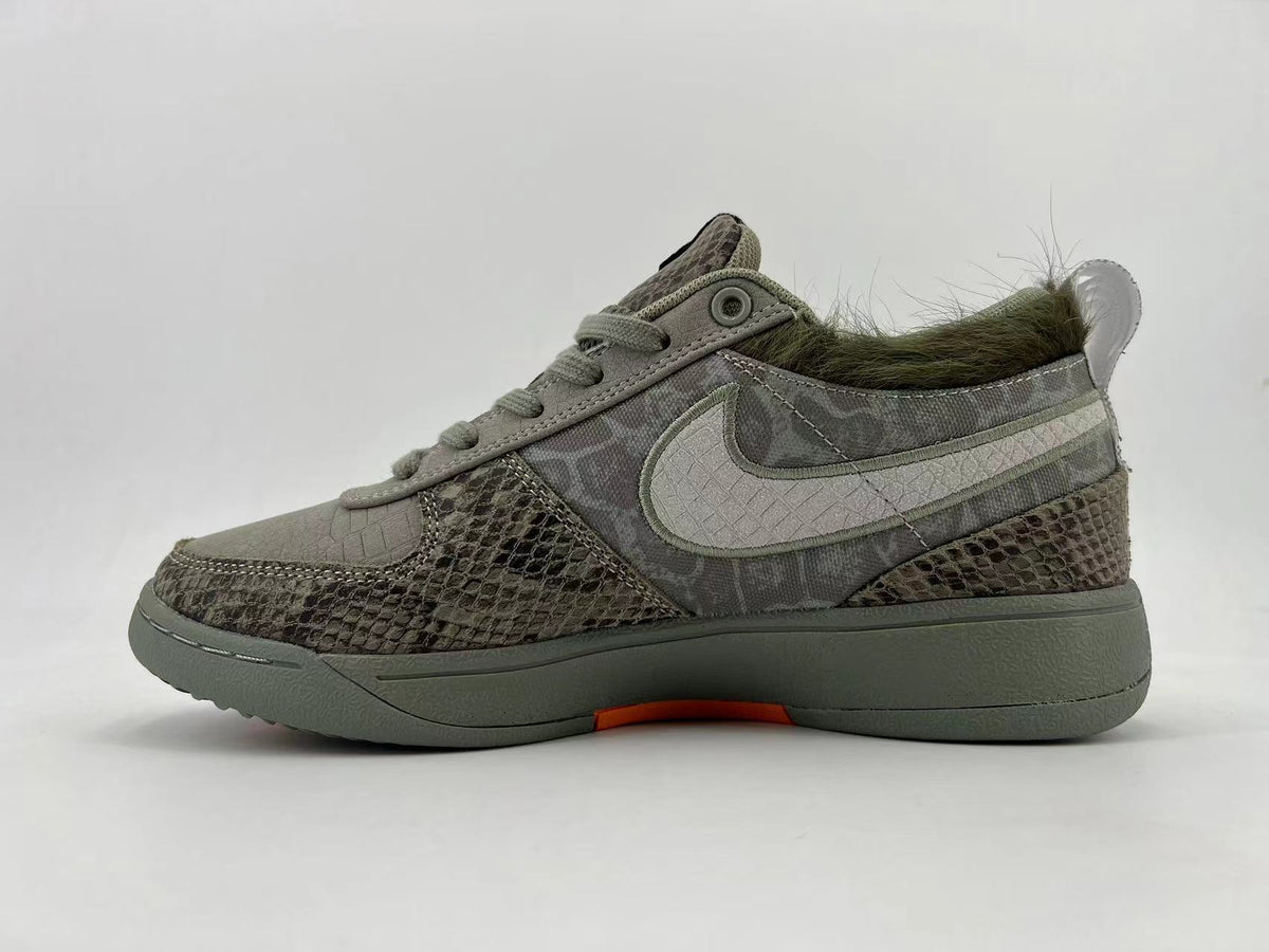 Side profile of the gray patterned sneakers with a light Swoosh and orange outsole accent