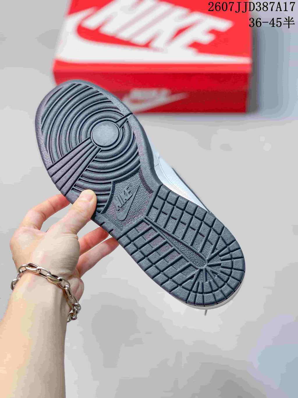 Close view of the sneaker outsole showing circular forefoot grooves and rectangular tread blocks.