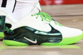 Side view of a white and green Nike LeBron 22 sneaker with a black side panel and green laces