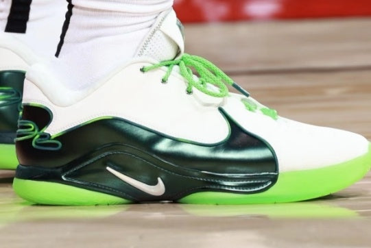 Side view of a white and green Nike LeBron 22 sneaker with a black side panel and green laces