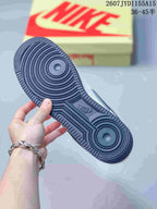 Close-up of the dark navy rubber outsole with concentric traction patterns on a Nike Air Force 1 sneaker.