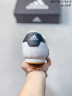 Rear view of the white sneaker showing the dark heel tab, adidas logo and gum outsole edge.
