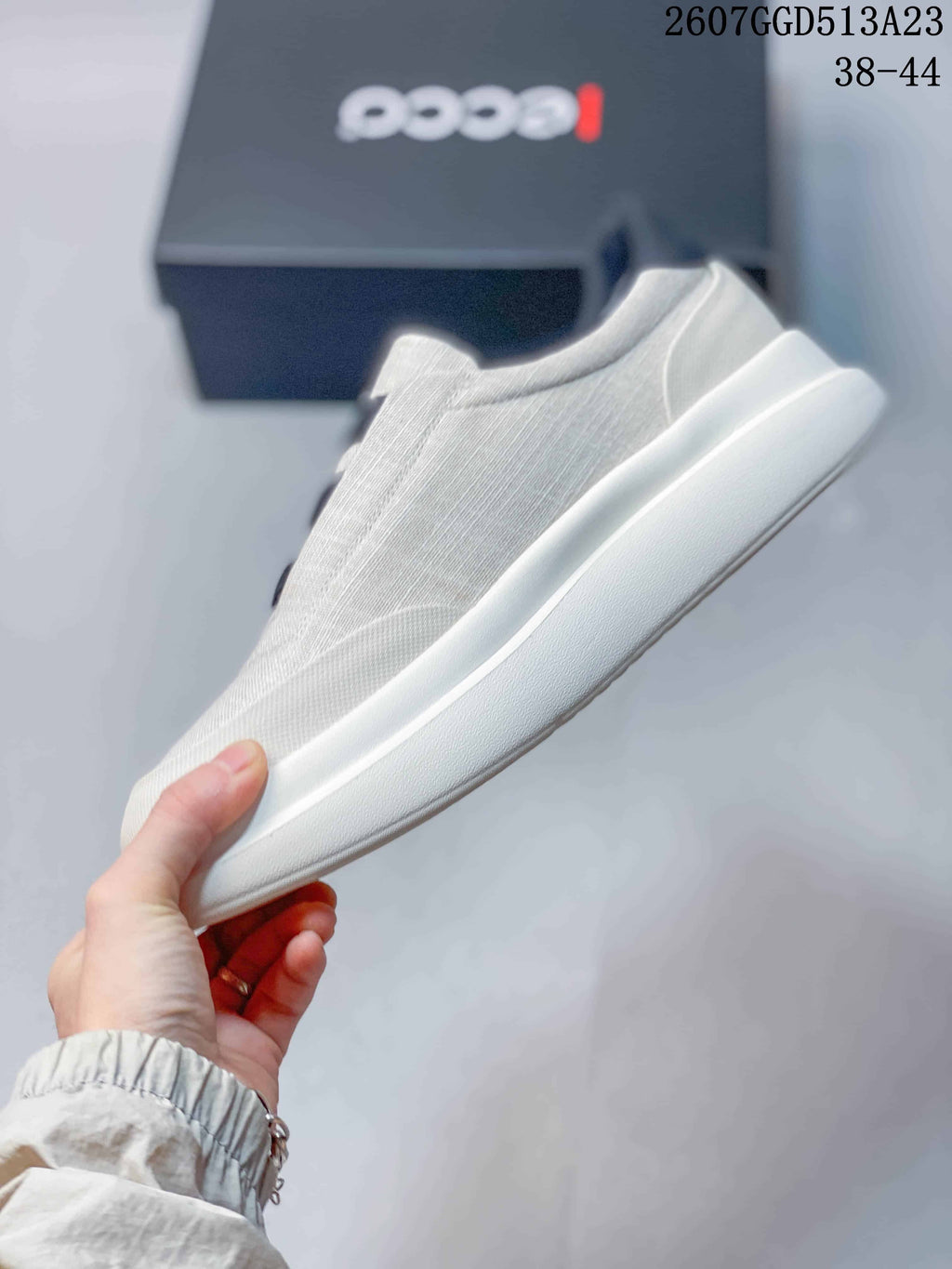Side profile of the light gray sneaker highlighting the low-profile upper and raised white outsole.