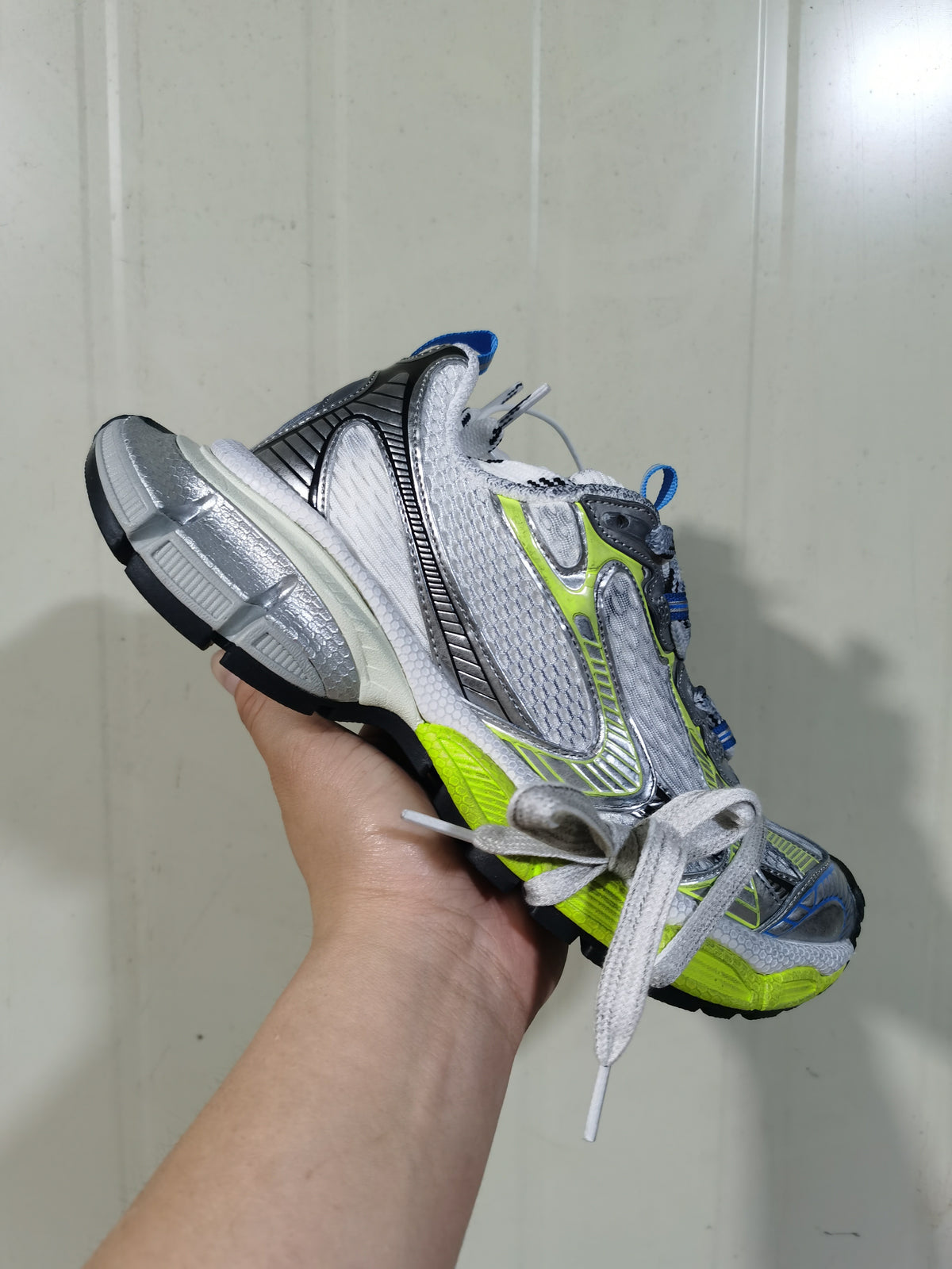 Angled view showing the layered side panels, laces, padded collar and segmented outsole of the sneakers.