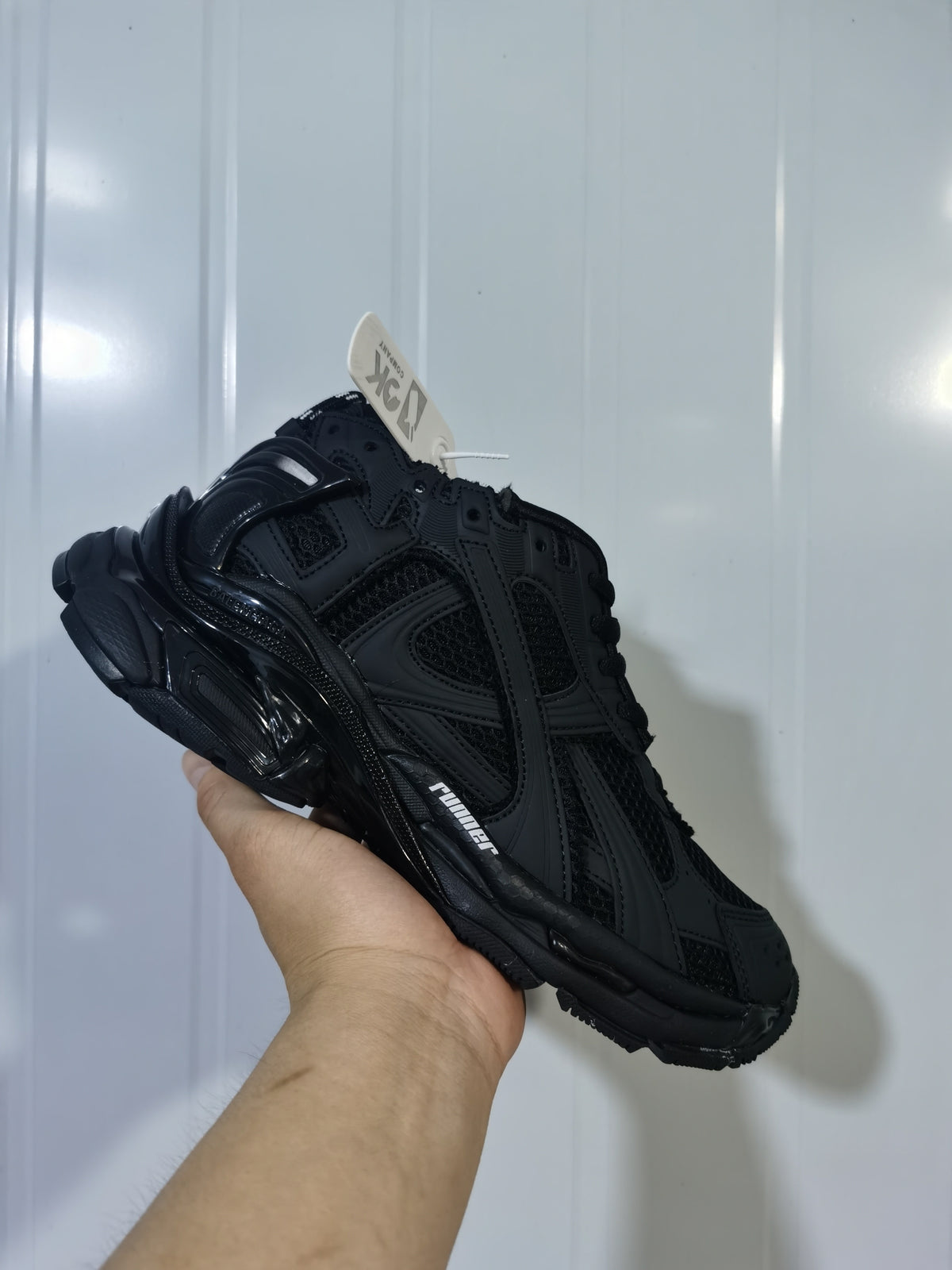 Black matte Balenciaga Runner sneaker shown at an angled front view with layered panels, mesh sections and a chunky outsole.