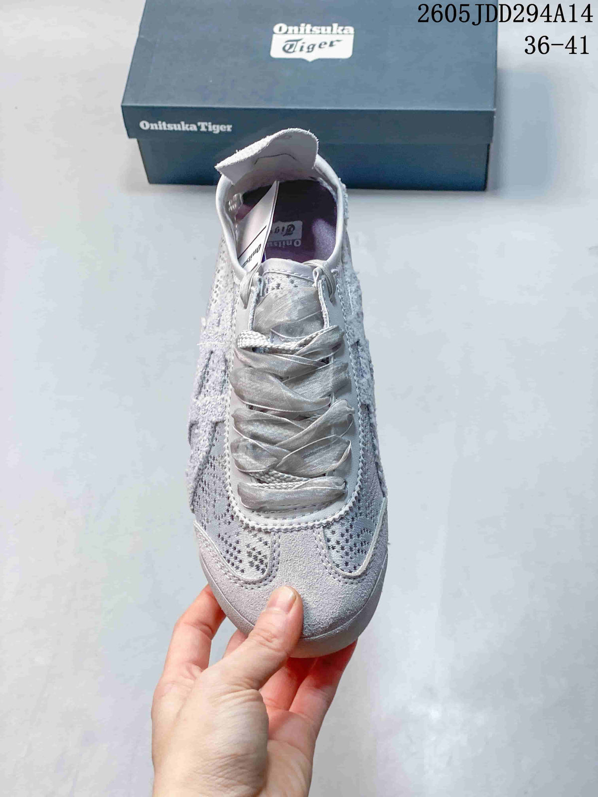 Top view of the light gray sneaker showing the rounded toe, patterned textile panels, tongue, and wide matching laces.