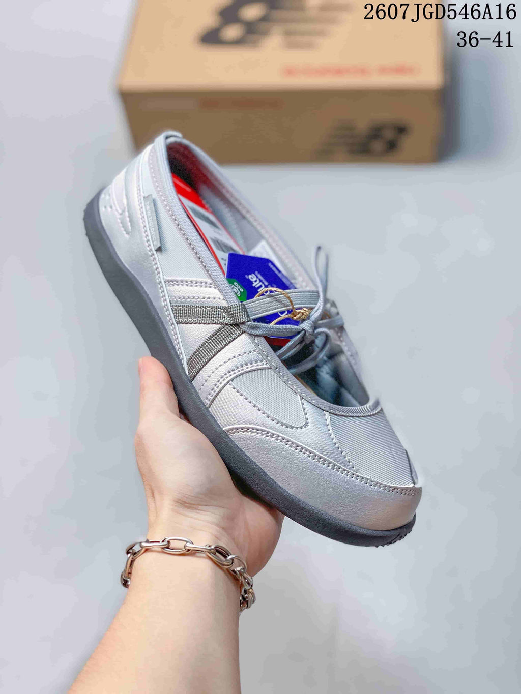 Angled side view of the silver-gray shoe showing the Mary Jane-inspired straps, stitched upper panels, rounded toe, and dark outsole.
