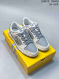 Pair of grey, white, and yellow Nike SB Dunk Low sneakers on a yellow box