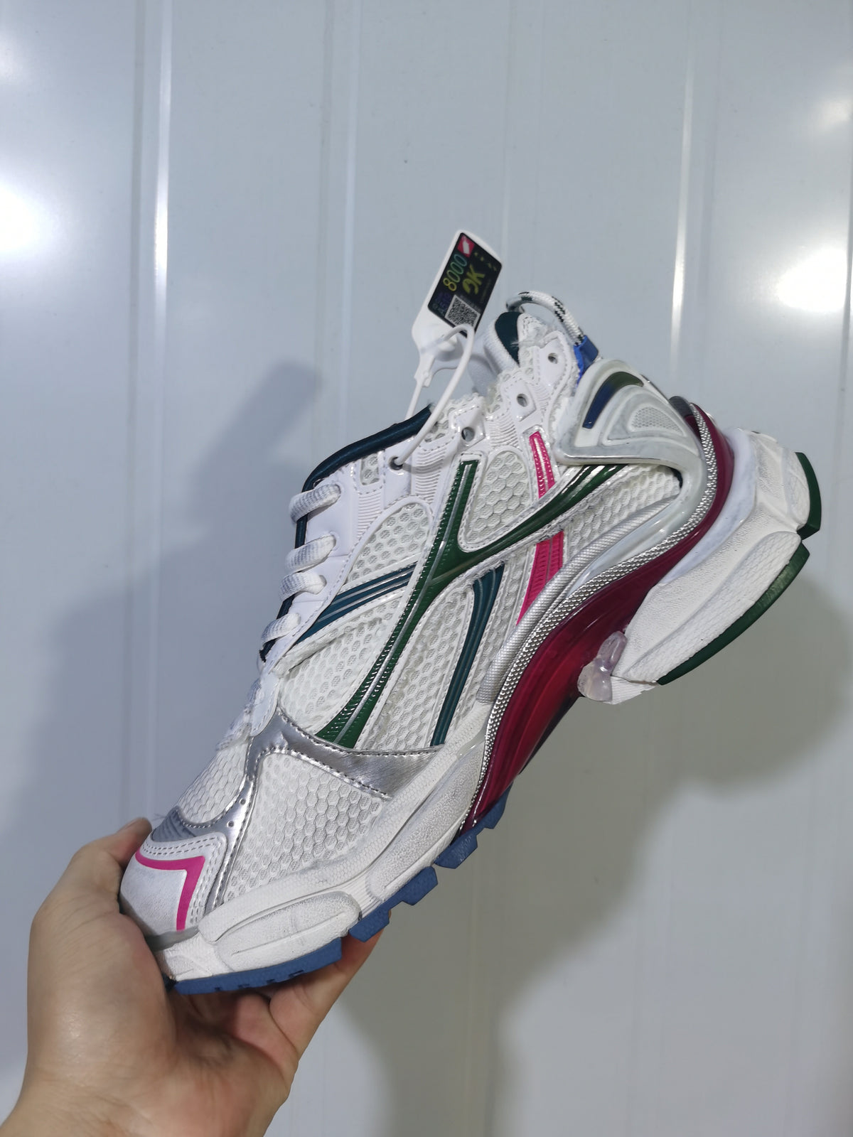 Close-up view of a white Puma 9934 sneaker with dark green, blue, pink, and silver accents.