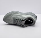 Top-down view of one gray sneaker highlighting the laces, tongue logo, collar, and textured upper.