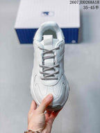 Top view of the white sneaker showing the padded collar, tongue, patterned laces and layered toe construction.