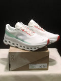 Pair of white On Cloudmonster 1 sneakers shown from a front three-quarter angle on their box; the box label shows Ivory/Creek and EU 40 for the photographed sample.