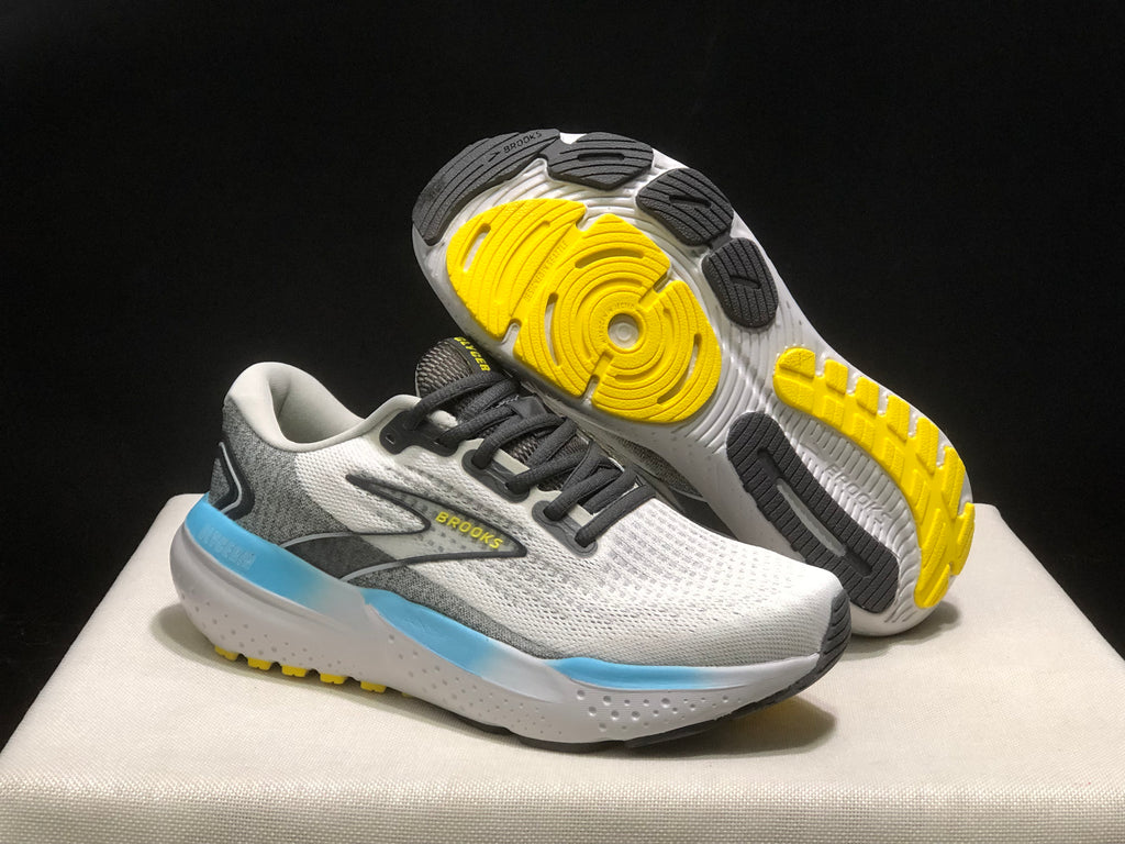 Brooks Glycerin 21 shoes shown from the side and outsole, with black and yellow tread sections visible beneath the white sole.