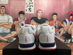 Rear view of the white basketball shoes showing textured panels and navy heel accents.