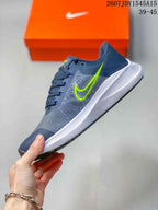 Side view of a gray and navy Nike Zoom Winflo 8 shoe with lime green Swoosh branding and a white sculpted midsole.