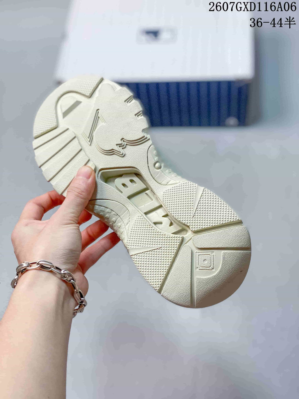 Close-up of the cream beige sneaker outsole showing its chunky segmented tread pattern.